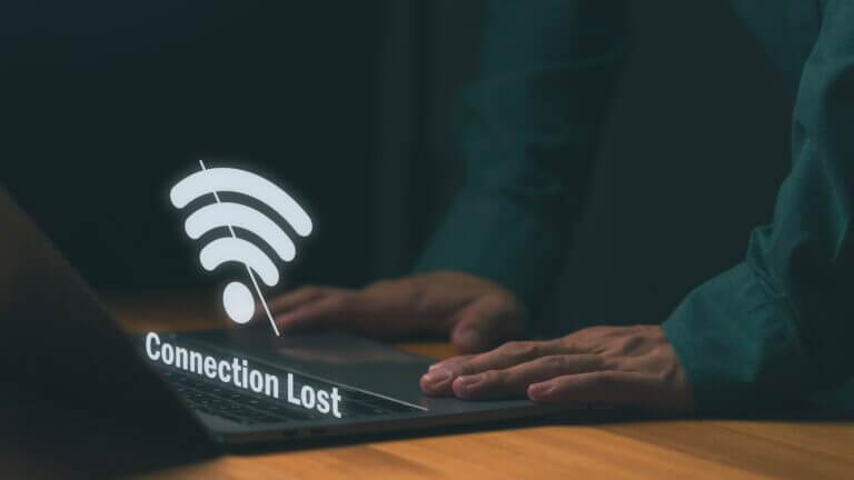 Close-up of person using laptop with Wi-Fi icon and Connection Lost, symbolizing internet disconnection or network failure. Concept for online issues, connectivity problems, or system downtime.